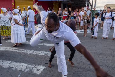 Bir grup insan, Aparecida de Goiania 'daki Yaşlı Siyah Geçit Töreni' nde Capoeira savaşını gösteriyor..