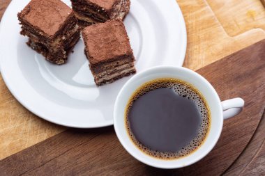 Tahta yüzeyinde İtalyan pipetinin parçaları olan bir fincan kahve..