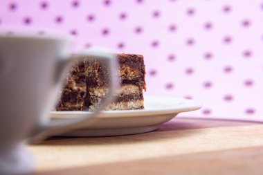 Pembe bir yüzeyde üzerinde İtalyan pipetinin parçaları olan bir fincan kahve..