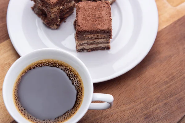 Tahta yüzeyinde İtalyan pipetinin parçaları olan bir fincan kahve..