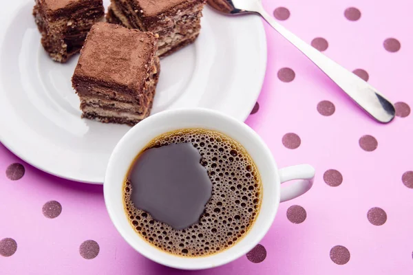 Pembe bir yüzey üzerinde İtalyan pipetinin parçaları olan bir fincan kahve..