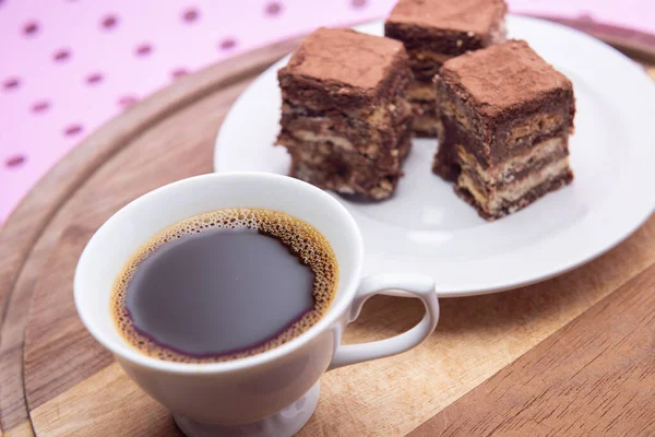 Pembe bir yüzeyde üzerinde İtalyan pipetinin parçaları olan bir fincan kahve..