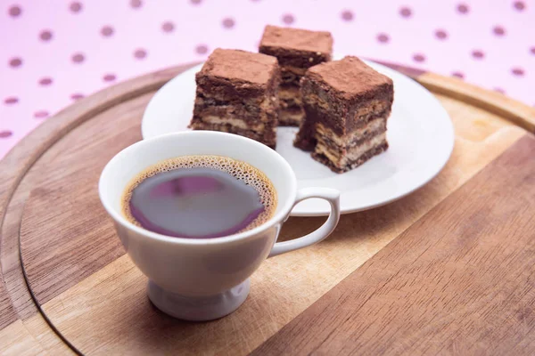 Pembe bir yüzeyde üzerinde İtalyan pipetinin parçaları olan bir fincan kahve..