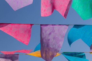 Arka planda mavi gökyüzü olan çamaşır ipinde birçok renkli flamalar asılı. Festa Junina. Quadrilha.