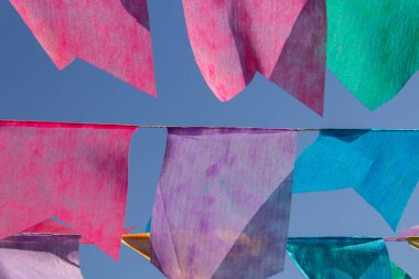 Arka planda mavi gökyüzü olan çamaşır ipinde birçok renkli flamalar asılı. Festa Junina. Quadrilha.