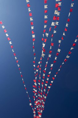 Bazı beyaz ve kırmızı çizgiler, arka planda mavi gökyüzü asılı.