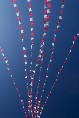 Bazı beyaz ve kırmızı çizgiler, arka planda mavi gökyüzü asılı.