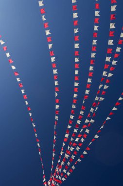 Bazı beyaz ve kırmızı çizgiler, arka planda mavi gökyüzü asılı.