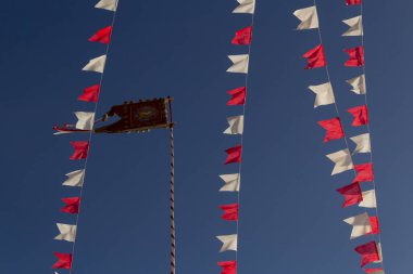 Kutsal Babamızın tacını taşıyan bayrak direğe işlenmiş, etrafında bayraklar olan..