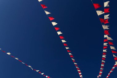 Bazı beyaz ve kırmızı çizgiler, arka planda mavi gökyüzü asılı.