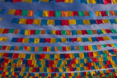 Several clotheslines with fabric flags against the blue sky for june party - typical brazilian festival. 