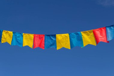 Haziran partisi için mavi gökyüzüne karşı kumaş flamalı bir çamaşır ipi - tipik Brezilya festivali. 