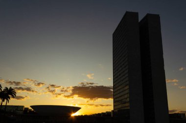 Brasilia Ulusal Kongresi 'nin siluetinde gün batımı öğleden sonra arka planda. Sarımsı tonları olan gökyüzü.
