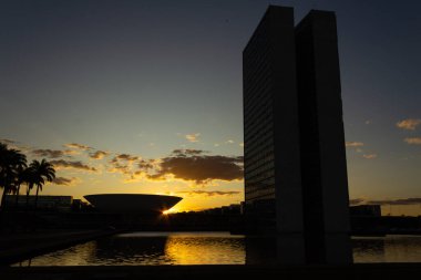 Brasilia Ulusal Kongresi 'nin siluetinde gün batımı öğleden sonra arka planda. Sarımsı tonları olan gökyüzü.