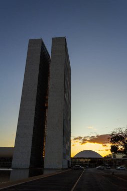 National Congress of Brasilia with sunset in the background in the late afternoon. Sky with yellowish tones.