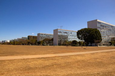 Braslia 'daki Bakanlar Kurulu' nun panoramik fotoğrafı. Açık havada mavi gökyüzü olan binaların olduğu şehir manzarası.