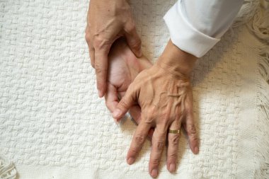 Closeup of masseuse hands applying therapeutic massage on a patient's hand.