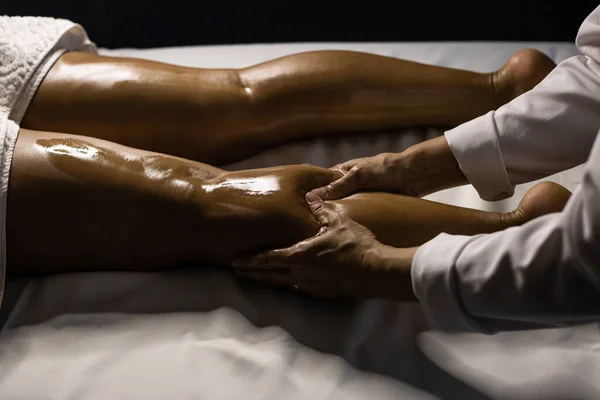 Therapist Dressed White Massaging Leg Patient Lying Stretcher Using Therapeutic — Zdjęcie stockowe
