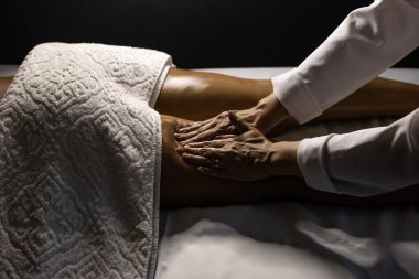 Therapist doing massage to patient. Therapist doing massage on patient's leg.