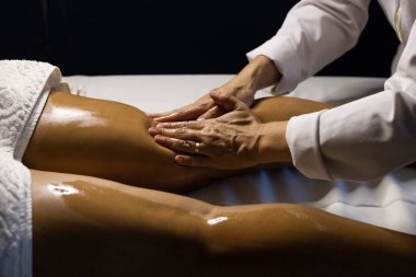 Therapist doing massage to patient. Therapist doing massage on patient's leg.