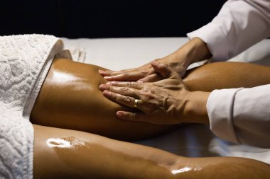 Therapist doing massage to patient. Therapist doing massage on patient's leg.