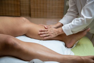 Therapist doing massage to patient. Therapist doing massage on patient's leg.