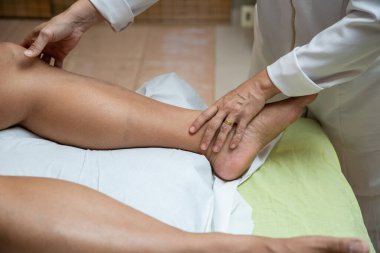 Therapist doing massage to patient. Therapist doing massage on patient's leg.