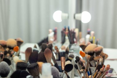 Detail of several brushes arranged on a vanity bench with lights.