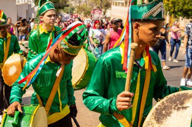 Yeşil elbiseli, dans eden ve perküsyon enstrümanları çalan katılımcılar, tipik bir Brezilya dini festivali olan Congadas 'ta.