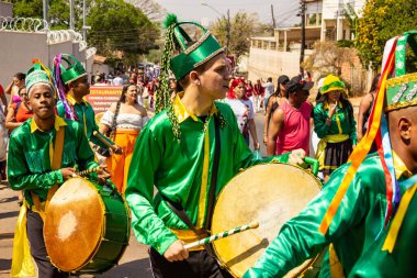 Yeşil elbiseli, dans eden ve perküsyon enstrümanları çalan katılımcılar, tipik bir Brezilya dini festivali olan Congadas 'ta.