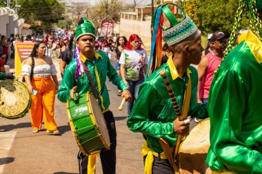 Yeşil elbiseli, dans eden ve perküsyon enstrümanları çalan katılımcılar, tipik bir Brezilya dini festivali olan Congadas 'ta.