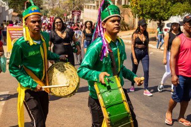 Yeşil elbiseli, dans eden ve perküsyon enstrümanları çalan katılımcılar, tipik bir Brezilya dini festivali olan Congadas 'ta.