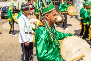 Yeşil elbiseli, dans eden ve perküsyon enstrümanları çalan katılımcılar, tipik bir Brezilya dini festivali olan Congadas 'ta.