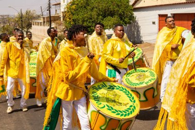 Bazı şenlikler sarı giyinmiş, perküsyon enstrümanları çalıyor, şarkı söylüyor ve dans ediyor, Goinia 'daki Kongadas sırasında, bir Afro-Brezilya kültürel ve dini dışavurumu.