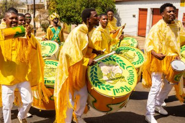 Bazı şenlikler sarı giyinmiş, perküsyon enstrümanları çalıyor, şarkı söylüyor ve dans ediyor, Goinia 'daki Kongadas sırasında, bir Afro-Brezilya kültürel ve dini dışavurumu.