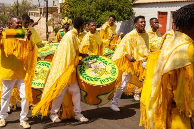 Bazı şenlikler sarı giyinmiş, perküsyon enstrümanları çalıyor, şarkı söylüyor ve dans ediyor, Goinia 'daki Kongadas sırasında, bir Afro-Brezilya kültürel ve dini dışavurumu.