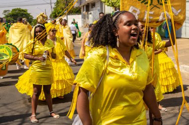 Sarı elbiseli bir grup Goiania 'daki Kongadas sırasında şarkı söyleyip dans ediyor..