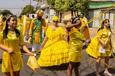 Sarı elbiseli bir grup Goiania 'daki Kongadas sırasında şarkı söyleyip dans ediyor..