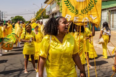 Sarı elbiseli bir grup Goiania 'daki Kongadas sırasında şarkı söyleyip dans ediyor..