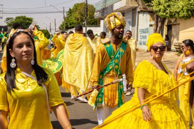 Sarı elbiseli bir grup Goiania 'daki Kongadas sırasında şarkı söyleyip dans ediyor..