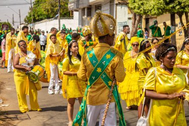 Sarı elbiseli bir grup Goiania 'daki Kongadas sırasında şarkı söyleyip dans ediyor..