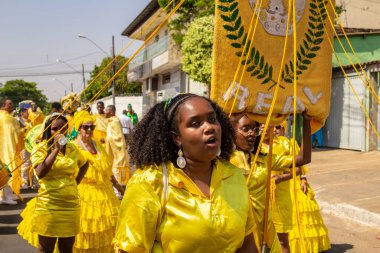 Sarı elbiseli bir grup Goiania 'daki Kongadas sırasında şarkı söyleyip dans ediyor..
