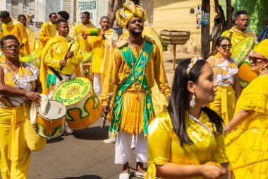 Sarı elbiseli bir grup Goiania 'daki Kongadas sırasında şarkı söyleyip dans ediyor..