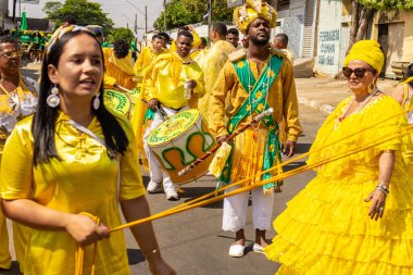 Sarı elbiseli bir grup Goiania 'daki Kongadas sırasında şarkı söyleyip dans ediyor..