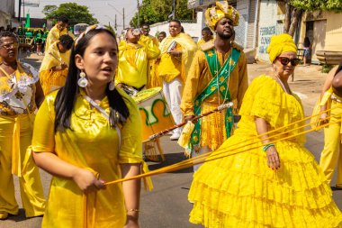 Sarı elbiseli bir grup Goiania 'daki Kongadas sırasında şarkı söyleyip dans ediyor..