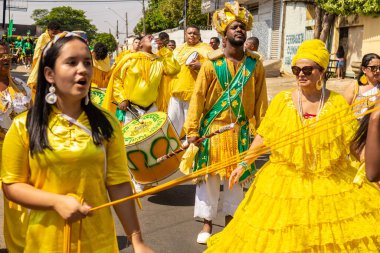 Sarı elbiseli bir grup Goiania 'daki Kongadas sırasında şarkı söyleyip dans ediyor..