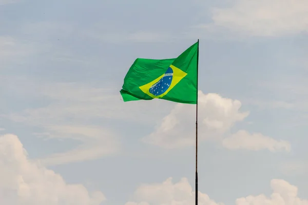 ブラジルの旗が飛んで 背景に曇った空で風になびく — ストック写真