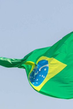 Arka planda gökyüzü dalgalanırken rüzgarda dalgalanan Brezilya bayrağının ayrıntıları.