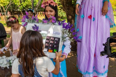 Elektronik oy sandığı gibi giyinmiş genç bir kadın insanları oy vermeye teşvik ediyor. Oy vermenin önemine dair farkındalığı artırmak için Lago das Rosas Parkı 'nda yapılan eylem.