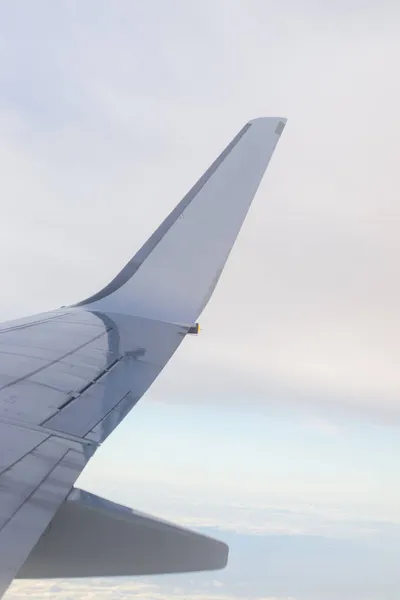 Bulutlu bir günde havada beyaz bir uçak kanadı